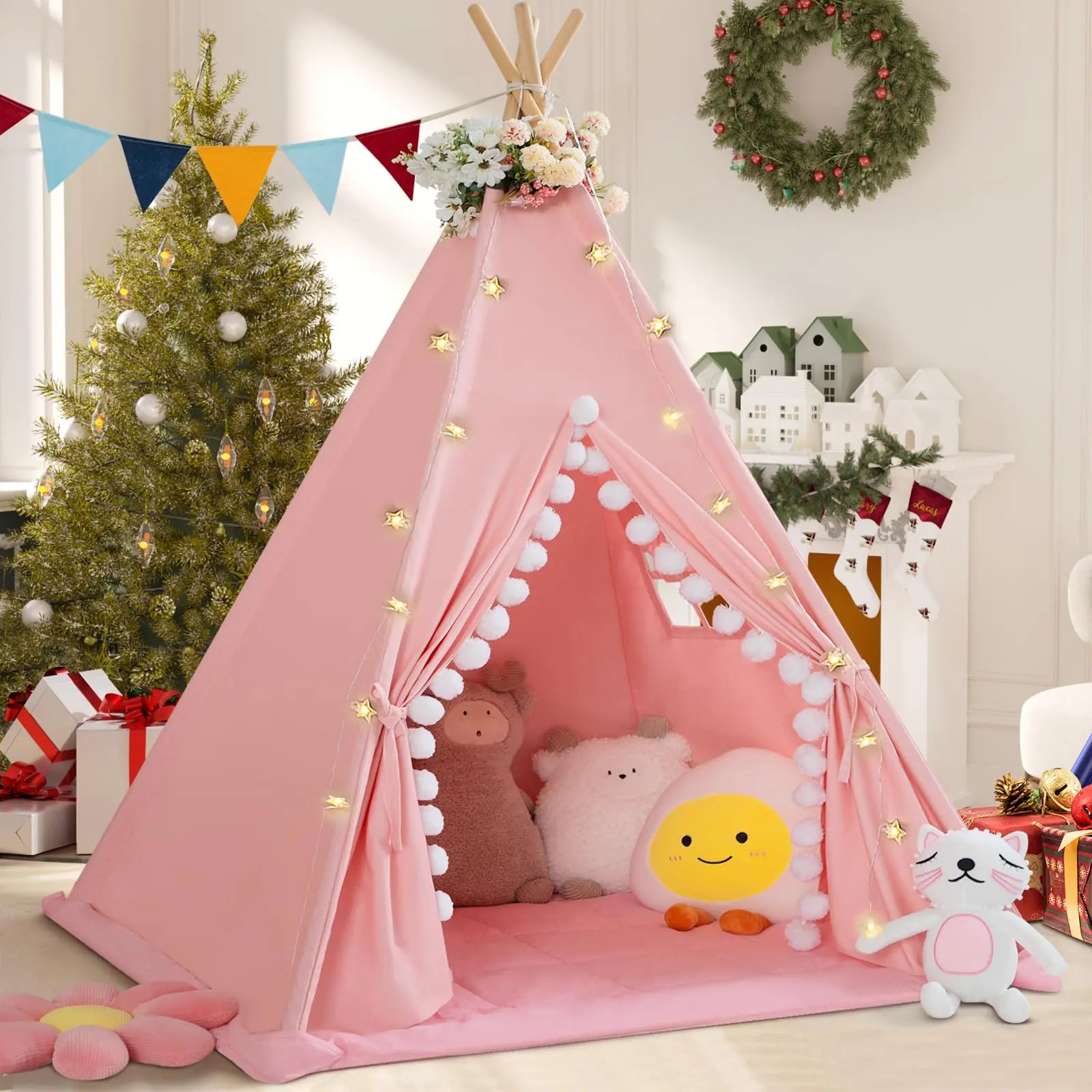 Pink children's teepee with toys in a decorated room with Christmas tree and wreath.